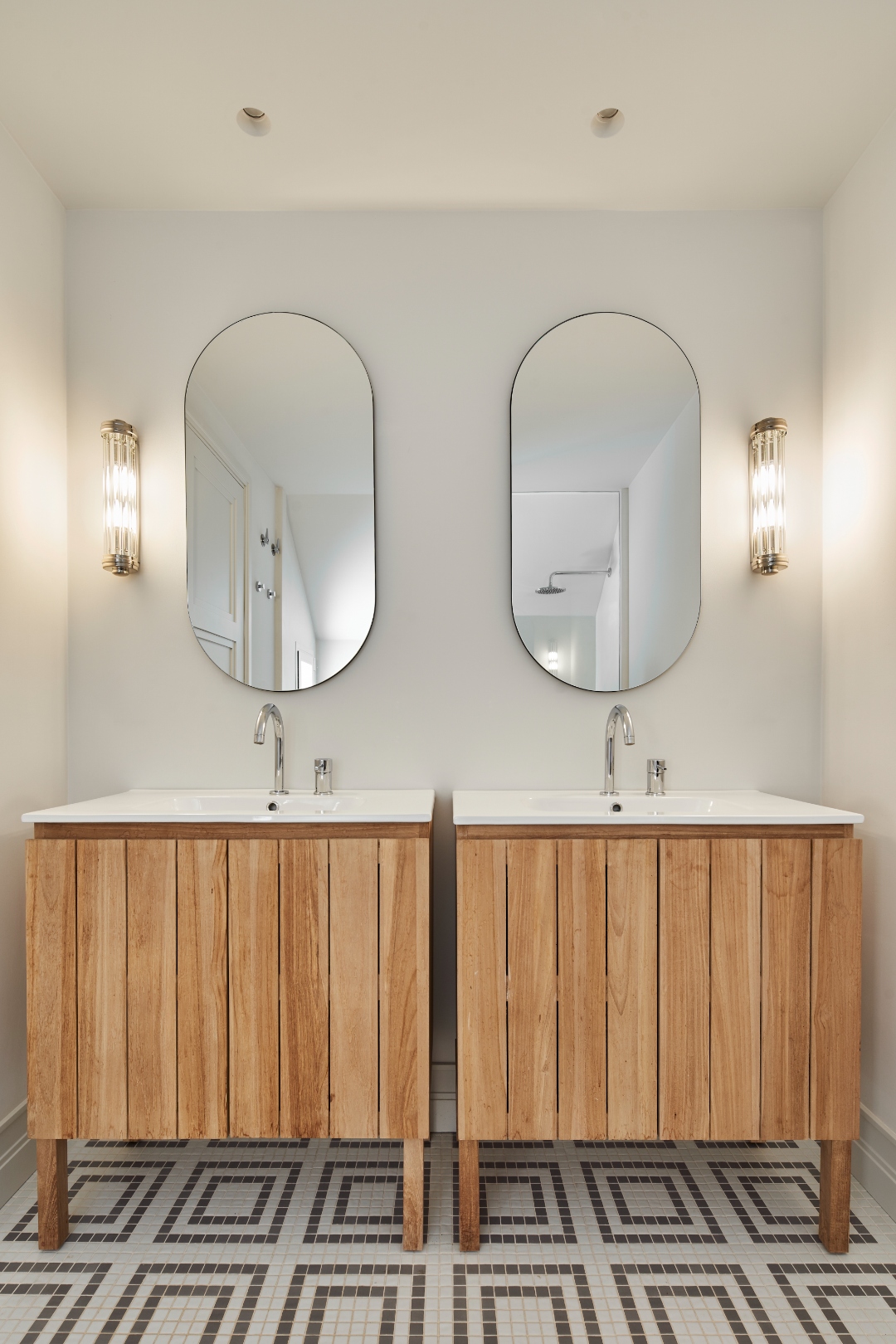 Bathroom — double vanity units, oval mirrors, mosaic tile floor