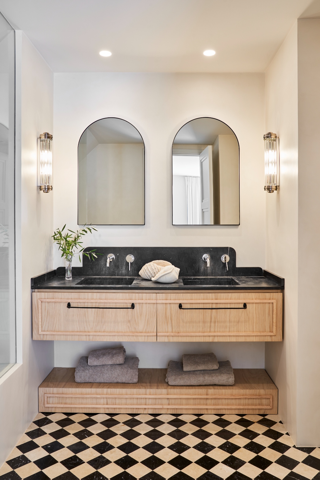 Master en-suite — double vanity, black marble worktop, arched mirrors, checker tile