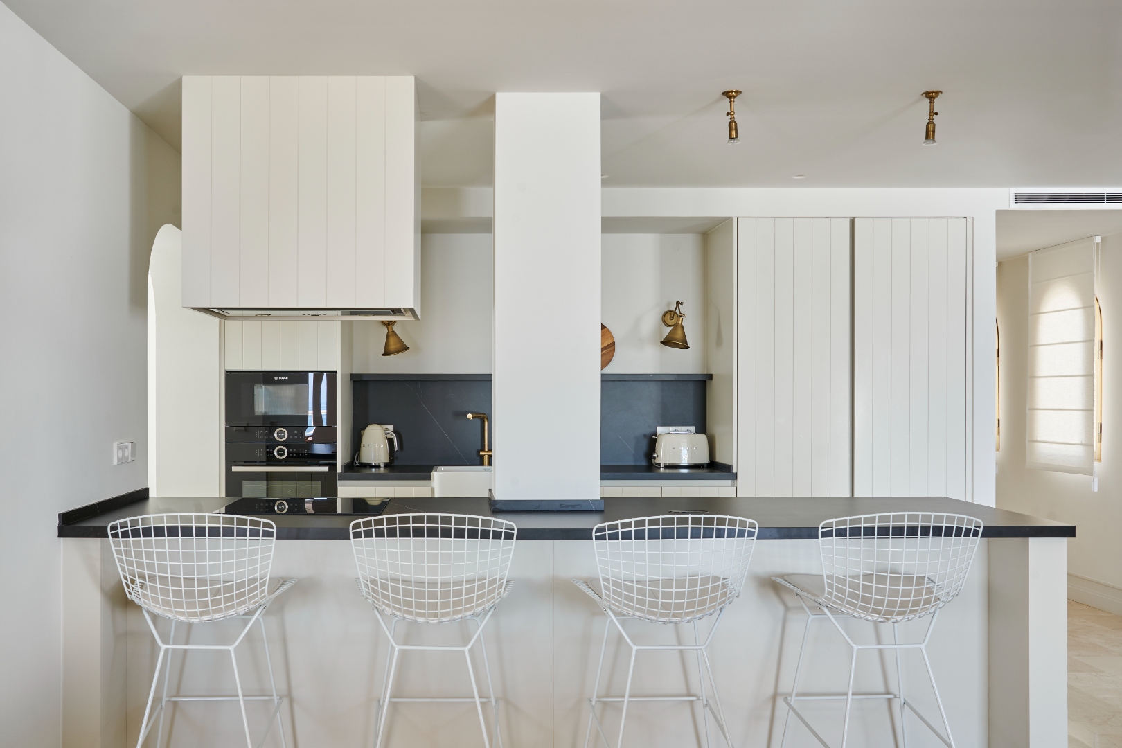 Kitchen island at Terraza Del Sol — Bertoia bar stools, black marble worktop