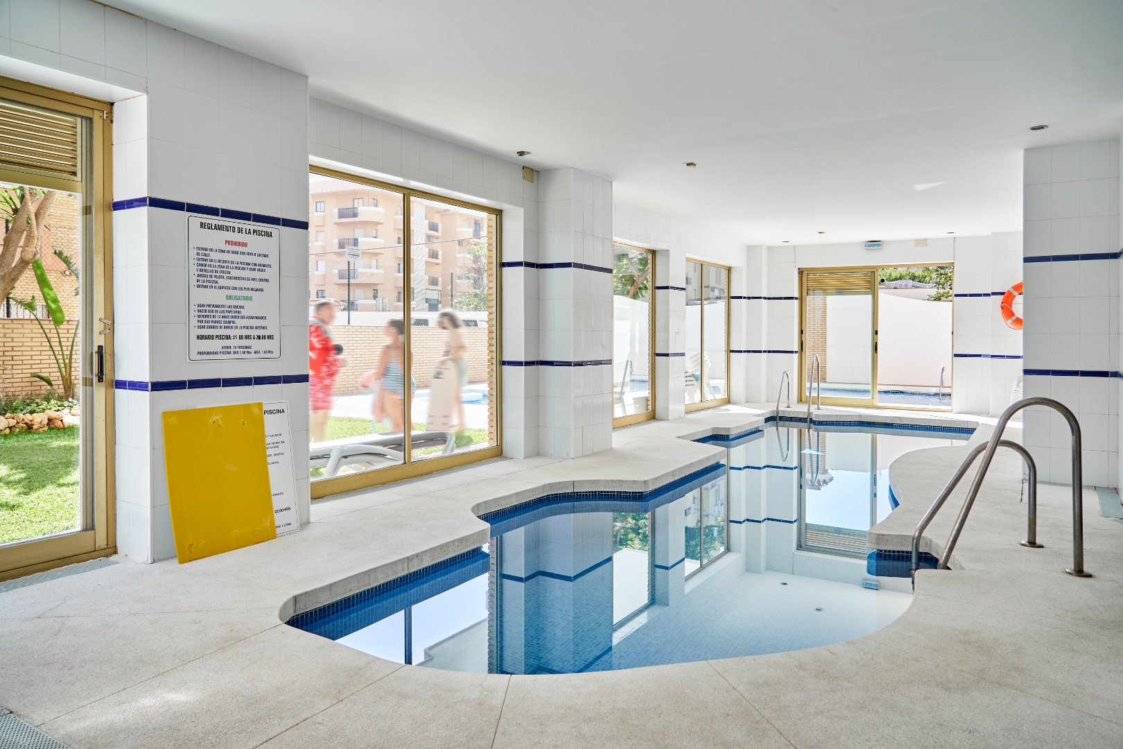 Indoor pool at Terraza Del Sol building — heated, with outdoor pool visible through glass