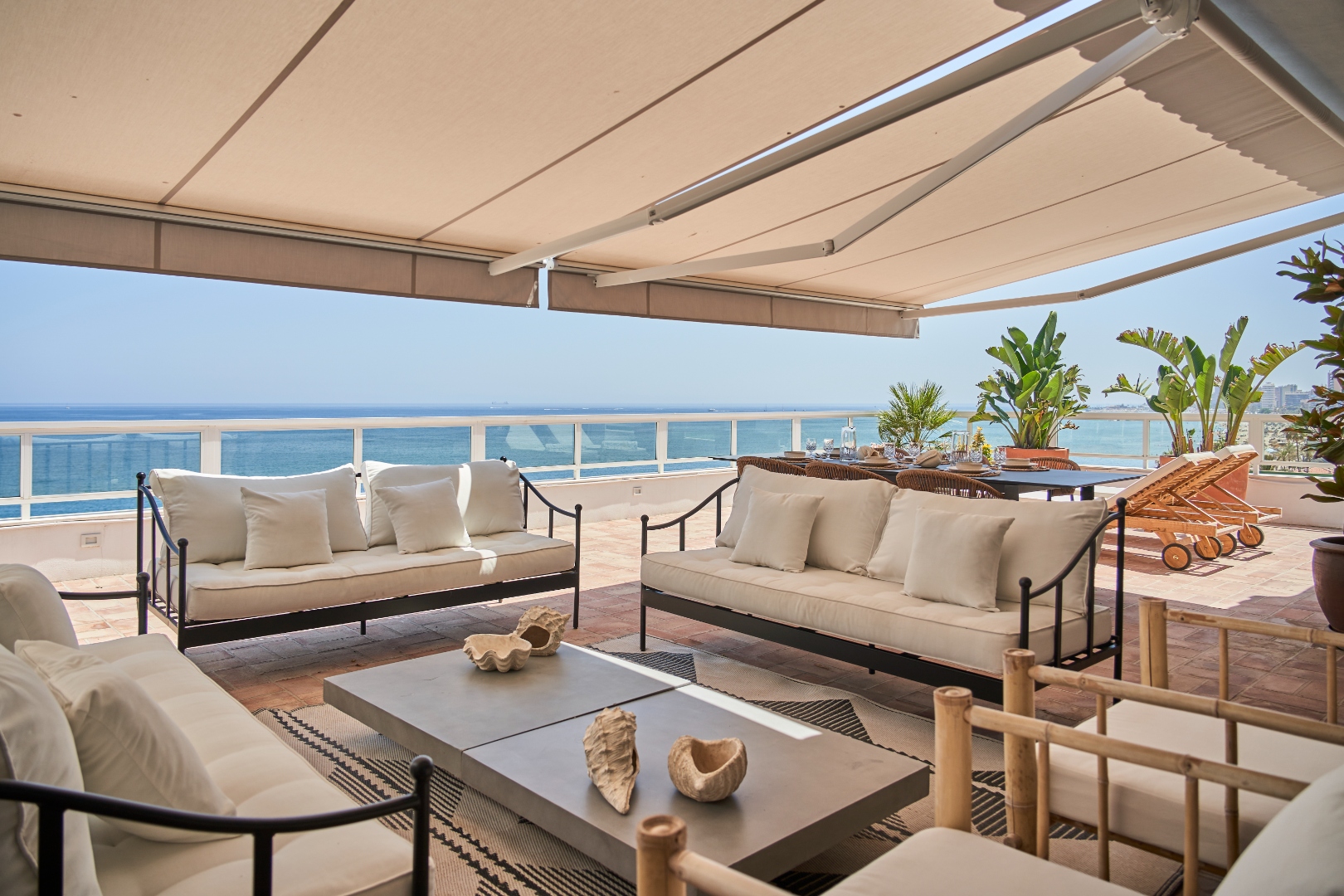 Terraza Del Sol terrace lounge — bamboo chairs, white sofas, dining and open sea
