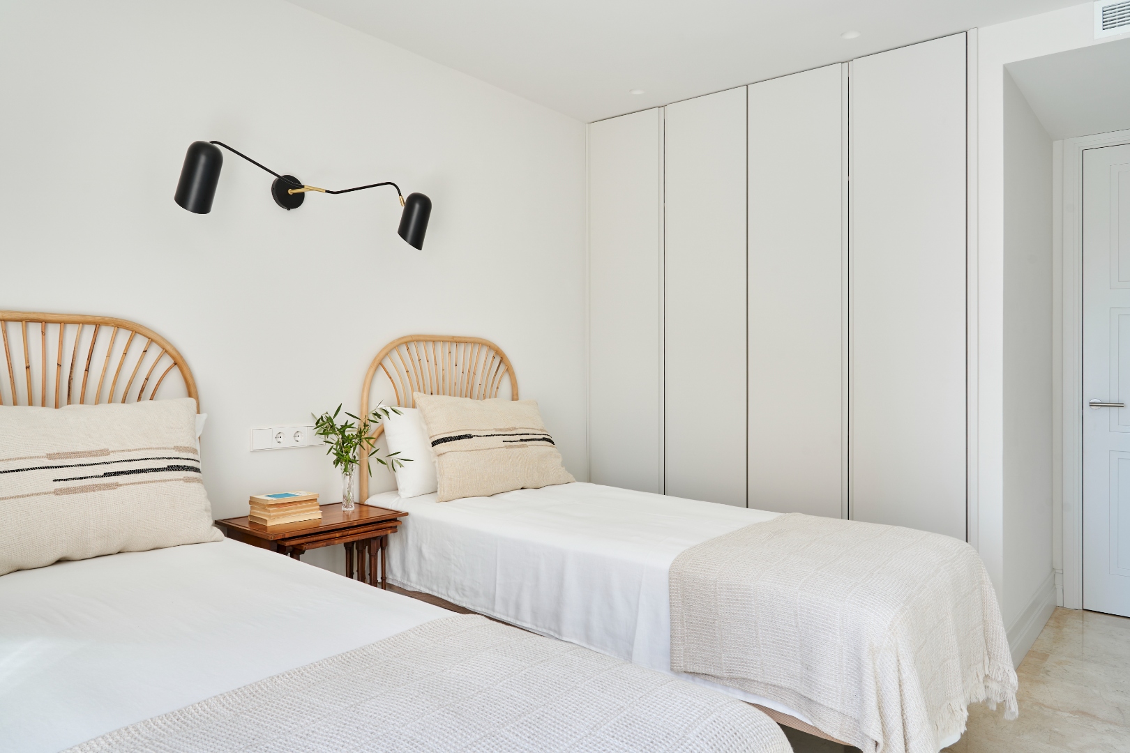 Twin bedroom — rattan headboards, fitted wardrobe, en-suite door