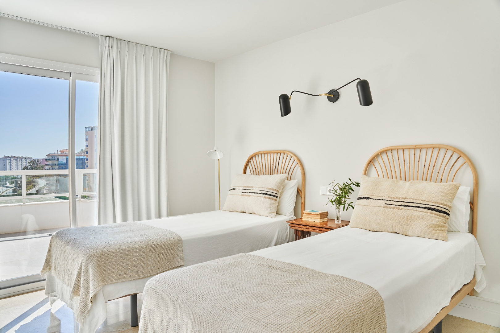 Twin bedroom — rattan headboards, window with natural light